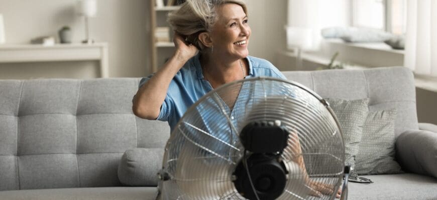 Happy,Attractive,Older,Woman,Sitting,Comfortably,On,Cozy,Couch,In
